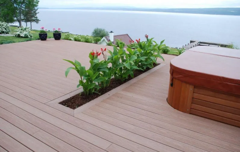 Tarima de exterior junto a un lago con jardineras integradas